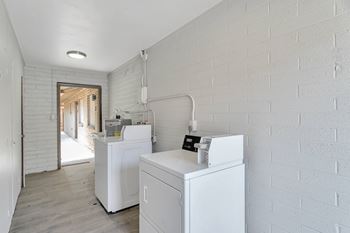 A white laundry room with a washer and dryer.